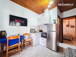 a kitchen with a refrigerator and a table and chairs at Cypress Seaside Apartment #PROPERTLY in Nea Kallikrateia