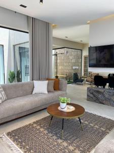 a living room with a couch and a table at شاليهات نافارو in Ghurābah