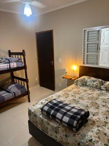 a bedroom with a bed with a blanket on it at Pousada São Luiz in Bragança Paulista