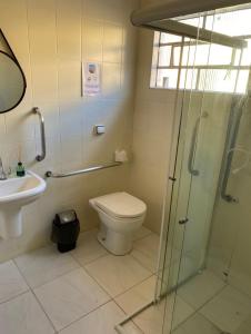 a bathroom with a toilet and a glass shower at Pousada São Luiz in Bragança Paulista