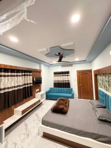 a bedroom with a bed and a blue couch at Hotel Shree Radhe Krishna in Ujjain