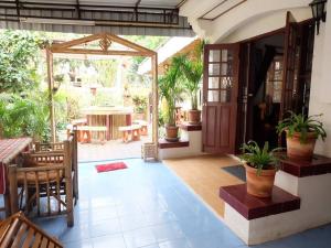 an open patio with a table and chairs and plants at Hug Glur House Tour and Hostel in Chiang Mai