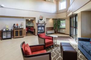 a living room with red chairs and a couch at Comfort Inn & Suites West Springfield in West Springfield