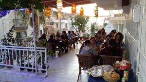 eine Gruppe von Personen, die in einem Restaurant an Tischen sitzen in der Unterkunft Ozgun Apart Hotel in Kusadası