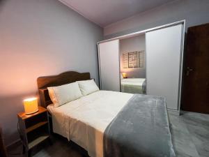 a bedroom with a bed and a lamp on a table at Casa Flor de Jacarandá in Alto Paraíso de Goiás