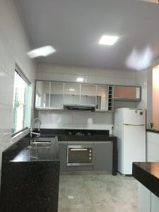 a kitchen with black counter tops and white appliances at Casa Flor de Jacarandá in Alto Paraíso de Goiás