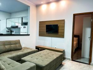 a living room with a couch and a flat screen tv at Casa Flor de Jacarandá in Alto Paraíso de Goiás