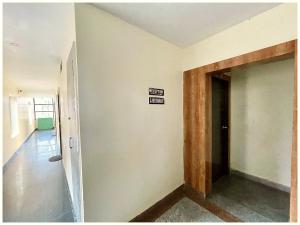 马图拉HOTEL K R - PREMIUM Near Krishna JanamBhoomi - Mathura Railway Juction - Bus stand - Parking and Wifi Facilities - Air Conditioning Luxury Room - A Top Rated Four Star Hotel的墙上没有入口标志的走廊