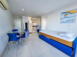 卡塔赫纳Apartamento Piso 18 Blue Horizon的一间卧室，里面有一张床、一张桌子和几把椅子。 更多16张照片