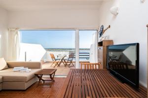 a living room with a large flat screen tv at NEW !! Studio Ria Formosa - Cabanas de Tavira in Cabanas de Tavira