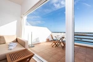 a balcony with a couch and a view of the ocean at NEW !! Studio Ria Formosa - Cabanas de Tavira in Cabanas de Tavira