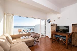 a living room with a couch and a television and a table at NEW !! Studio Ria Formosa - Cabanas de Tavira in Cabanas de Tavira