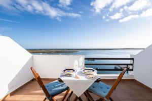 a table and chairs on a balcony with a view of the ocean at NEW !! Studio Ria Formosa - Cabanas de Tavira in Cabanas de Tavira +39 photos