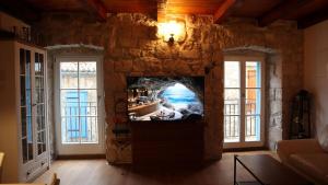 a living room with a tv in a stone wall at Vila More moje A2 in Vis
