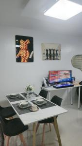 ein weißer Tisch mit Stühlen und ein Schreibtisch mit einem Laptop in der Unterkunft Anna's cozy house in Angeles