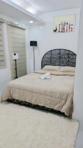 ein Schlafzimmer mit einem großen Bett in einem weißen Raum in der Unterkunft Anna's cozy house in Angeles