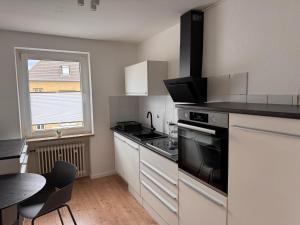 a kitchen with a stove top oven next to a table at ProStays Apartment in Mönchengladbach - 2 Schlafzimmer - 4 Betten in Mönchengladbach