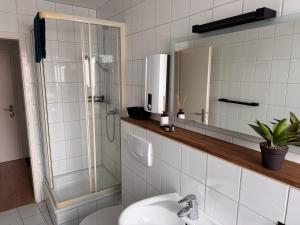 a bathroom with a shower and a sink and a mirror at ProStays Apartment in Mönchengladbach - 2 Schlafzimmer - 4 Betten in Mönchengladbach +4 photos