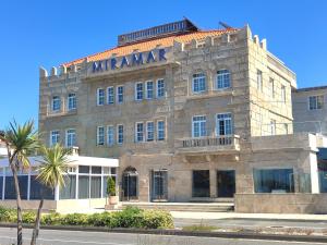 a large stone building with a manuscript sign on it at Hotel Miramar Playa America Nigran in Nigrán