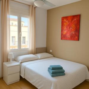 a bedroom with a bed with two towels on it at Avenida del Mar 14 Junio in Castellón de la Plana +22 photos