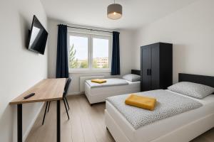 a small room with a bed and a desk and a window at Ideal für Monteure. 3 Zimmer Apartment mit Küche, Waschmaschine, WiFi usw... . in Nietleben