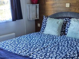 a bed with a blue comforter and two pillows at Westmorland 32 caravan in Ballantrae