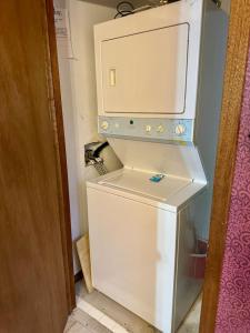 a small white refrigerator with a microwave on top of it at Mystical Haven Honeymoon Cabin in Sevierville