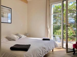 una camera da letto con un letto e una grande finestra di Au cœur de Trégastel, noyée dans la végétation a Trégastel