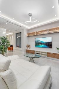 a living room with a white couch and a tv at Centrally Located Luxury Home with Views and Cinema in Vancouver