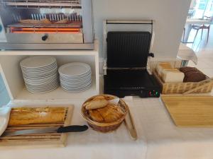 a shelf with plates and a basket of bread at Hotel Miramar Playa America Nigran in Nigrán