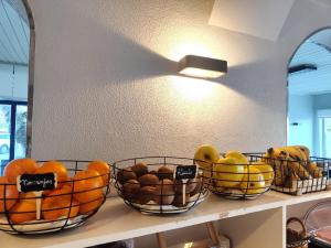 three baskets of fruit sitting on a shelf at Hotel Miramar Playa America Nigran in Nigrán