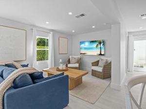 een woonkamer met een blauwe bank en een tafel bij Sand And Sea Bungalow in Naples