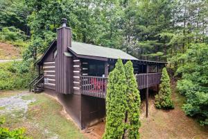 a cabin in the woods with a balcony and trees at Blissful Bear Heaven- Honeymoon Cabin in Sevierville