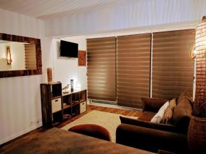 a living room with a couch and a tv at PARFUM d'OCEAN in Saint-Pierre-dʼOléron