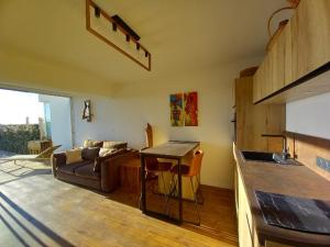 a living room with a couch and a kitchen at PARFUM d'OCEAN in Saint-Pierre-dʼOléron