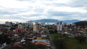 a view of a city with buildings and mountains at Lofts 4 Elementos - Terra - Martim de Sá - Caraguatatuba in Caraguatatuba