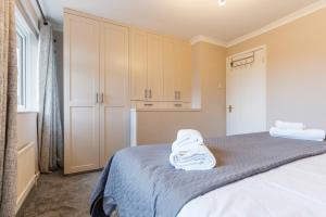 a bedroom with a bed with a white towel on it at 3Bed 2Bath nr Uni HertsHatfield in North Mimms