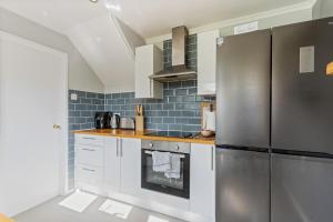 a kitchen with white cabinets and a stainless steel refrigerator at 3Bed 2Bath nr Uni HertsHatfield in North Mimms