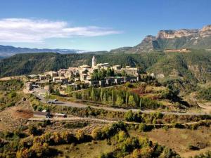 a village on a hill with mountains in the background at Rustic Mountain Retreat in La Puebla de Roda