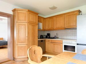 a kitchen with wooden cabinets and a table with a table at Ferienwohnung Gartenblick in Amerang