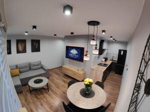 a living room with a table and a couch at Apartament IRESTAN - Komfortowy wypoczynek w sercu Karkonoszy in Jelenia Góra