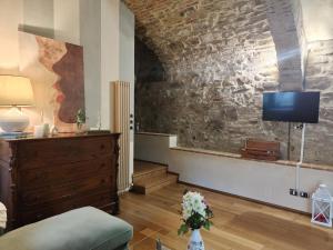 a living room with a couch and a tv on a wall at "Il Pollaio" guests house in Panicale
