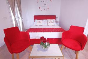 ein Zimmer mit einem Bett mit roten Stühlen und einem Tisch in der Unterkunft GD Case Vacanza - Suite del Conte - Salento Luxury Private Suite Idromassaggio in Specchia