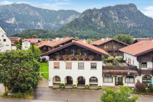 a large white house with flowers on the roof at Chiemgauzeit Ferienwohnung - Chiemgau Karte in Inzell
