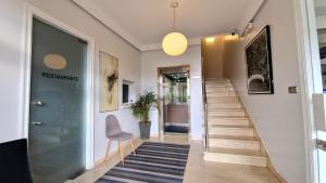 a hallway with stairs and a door and a chair at Hotel Miramar Playa America Nigran in Nigrán