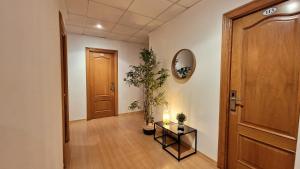 a hallway with a door and a table and a plant at Hotel Miramar Playa America Nigran in Nigrán