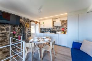 a kitchen and a dining room with a table and chairs at Social Lodge Galinho in Estreito da Calheta