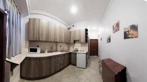 een keuken met houten kasten en een wit apparaat bij Apartment On the center of Lviv in Lviv