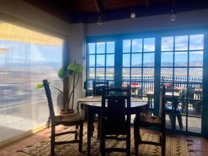 a dining room with a table and chairs and a window at Hostal Casa La Puntilla in Los Molles +16 photos