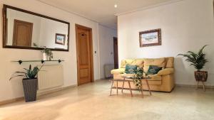 a living room with a couch and two plants at Hotel Miramar Playa America Nigran in Nigrán
